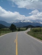 View down a paved highway with mountains on horizon